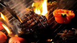 Steak and vegetables sizzle on a grill. Stock Footage