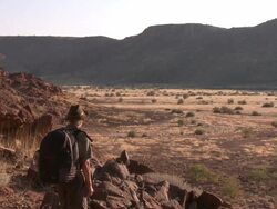 Hiker looking out over landscape, Twyfelfontein, Namibia Stock Footage
