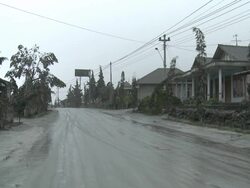 Road coated in thick layer of volcanic ash mud in village below Merapi volcano after eruption; Indonesia. 7 November 2010 / AUDIO Stock Footage
