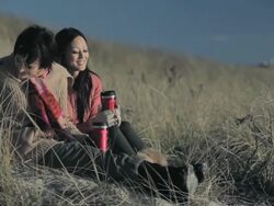 Friends sitting on dune with hot drink Stock Footage