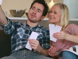 couple on sofa looking at paint samples Stock Footage