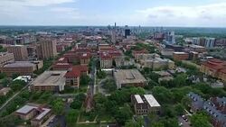 Really Far Wide Angle Campus UT Tower Aerial Fly by Austin Texas Over University of Texas at Austin Capital Cities with Downtown Cityscape Skyline in the background at Center moving forwards close with Pool and Amazing Architecture and Church in View Stock Footage