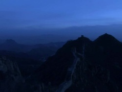A shot of the Great Wall of China at night, sitting on top of jagged mountain peaks.  Stock Footage