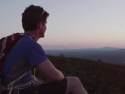 MS PAN Shot of Hiker resting to take in view with his dog on top of peak in 100 Mile Wilderness of Northern / Maine, United States  Stock Footage