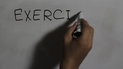 Hand writing a 'exercise everywhere' message on a white board using a black marker Stock Footage