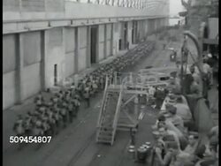 1942: U.S. MARINES: TRANSPORTATION: HA WS Marines in line marching on dock, ship FG. WS Soldiers, dock workers, crane lifting light tank M2A4, ship. MS Armored tank being lifted. Vehicles, equipment, weapons, arms, mobilizing, USA WWII Instructional Video