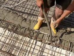 CU Shot of workmen working cement spreding on floor from cement bucket at construction site / Hermeskeil, Rhineland Palatinate, Germany Stock Footage