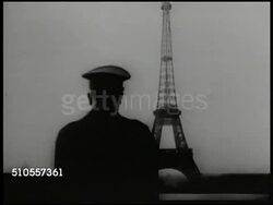 1940: HITLER IN FRANCE:  (POV moving vehicle) WS Nazi German officials in car driving toward Arc de Triomphe, Paris. WS Adolf Hitler w/ officers on balcony looking at Eiffel Tower. LA MS Hitler looking around. Instructional Video