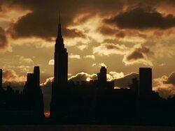 Time lapse of the sun rising behind the silhouettes of the empire state building, 34th street and the new yorker as clouds pass overhead Stock Footage