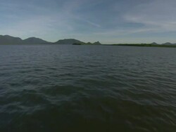Wide Shot push-in - Distant mountains of Hinchinbrook Island rise out of the ocean / Hinchinbrook Island, Australia Stock Footage