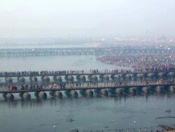 Millions of people crowd the banks of the Ganges, and the bridges spanning the river, as they travel to their respective festival destinations.  Kumbh Mela, India. Stock Footage