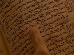 Arabic script in old book being followed by finger, with audio, sound available Stock Footage