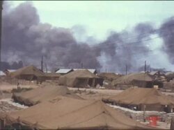 Amateur Vietnam Marine Footage of camp, tents and distant fires and explosions and dark smoke aginst bright skies â€“ Soldier mugging for the camera. Stock Footage