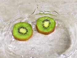 CU SLO MO Shot of Kiwi Fruits, actinidia chinensis, Slice rolling on Water and splashing / Calvados, Normandy, France Stock Footage