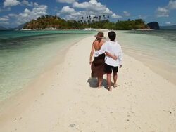 WS young man and woman having a romantic walk on idyllic sandbar towards tropical island in background / Snake Island, Bacuit Archipelago, El Nido, Palawan, Philippines Stock Footage