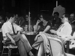 1950: PARIS, FRANCE: VS Patrons sitting outdoors at Cafe dex Deux Magots, woman w/ electronic hopping bunny at Cafe de la Paix, people smoking, eating, reading. VS Artist drawing Arc de Triomphe du Carrousel, traffic around the Arc de Triomphe. Instructional Video