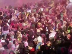 crowd of people at a Hindu festival throwing colored powder into the air Stock Footage