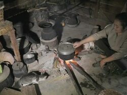MS woman sitting and cooking by fire / Xam Neua, Laos Stock Footage