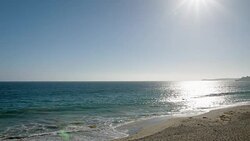 Sun reflecting in sea waves on a sunny beach Stock Footage