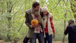 Children in skeleton costumes chase each other around parents Stock Footage