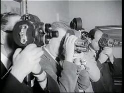 Three men use film cameras. News Clip