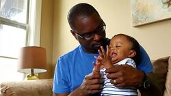 MS ZI ZO Father holding infant son on lap playing clapping game Stock Footage
