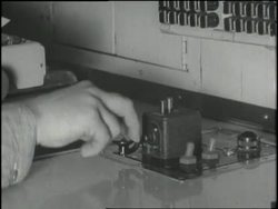 A man's hand taps Morse code on a telegraph. News Clip
