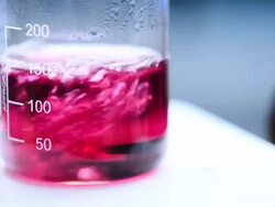 Boiling red liquid in beaker Stock Footage