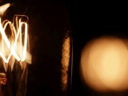 Timelapse close up zoom and track of an electric light bulb filament flickering on and off Stock Footage