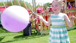 Girl playing with balloons in amusement park Stock Footage