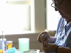 MS Elderly woman looking at pill with magnifying glass / Minneapolis, Minnesota, United States Stock Footage