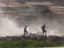 WS TS View of trashes and teenagers walking in smoke / Lagos, Nigeria Stock Footage