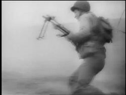 B/W June 6, 1944 soldier with gun in foxhole / soldier with gun lies in grass / Normandy, France / D-Day Stock Footage