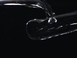 CU SLO MO Shot of two sources of water from left and right crash together mid frame against black / United Kingdom Stock Footage