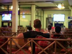 MS Young tourists watching  two big screens in bar /  Vang Vieng, Vientiane, Laos Stock Footage
