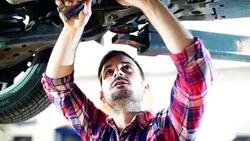Car mechanic working under a vehicle. Stock Footage