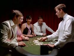 Medium shot two men and two women sitting at blackjack table / dealer dealing cards / paying winners Stock Footage