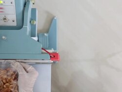 Dolly: Worker using Thermal Sealer to seal Food Package Stock Footage