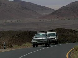 Two cars riding through desert landscape Stock Footage