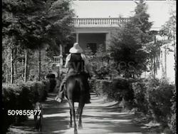 1934: MEXICO FARMLANDS: WS Sheep & cattle, country side. WS Mexican farmers hoeing, hacienda BG. WS Mexican on horse riding to house. WS Farmland, cattle FG, mountains BG. WS Farmer plowing field w/ cattle. MS Cattle pulling crude plow. CU Plow, soil. Instructional Video