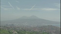 Vapor trails criss-cross above Mt. Vesuvius and the sprawling city of Naples. Stock Footage