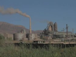 Cement Factory on the green field wide shot, wiith grass at the foreground Stock Footage