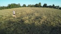 TRACKING AERIAL MS woman running in field Stock Footage
