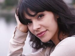 CU SLO MO Shot of beautiful brunette smiling while standing on bridge overlarge city river / Portland, Oregon, United States  Stock Footage