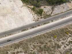 aerial view of cars traveling on freeway into tunnel Stock Footage