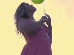 Woman holding balloons; UK Stock Footage