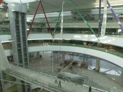 Extreme Long Shot tilt-down - Construction workers use a walkway in the atrium of a Hongqiao Airport terminal./Shanghai, China Stock Footage