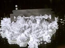 CU SLO MO Razor blade falling on drug powder against black background / Vieux Pont, Normandy, France Stock Footage