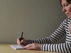 Woman writing in textbook Stock Footage