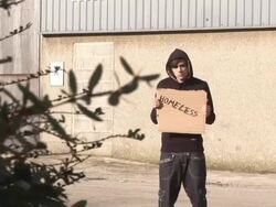Youth / Hoody holding sign saying 'Homeless' Stock Footage